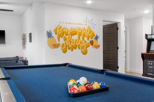 a pool table in a living room with a sign at Pineapple Shores - Stay for 14 in Hollister