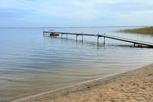 a dock in the water next to a beach at 30185-Ulfborg-Bellisvej-509 in Vang