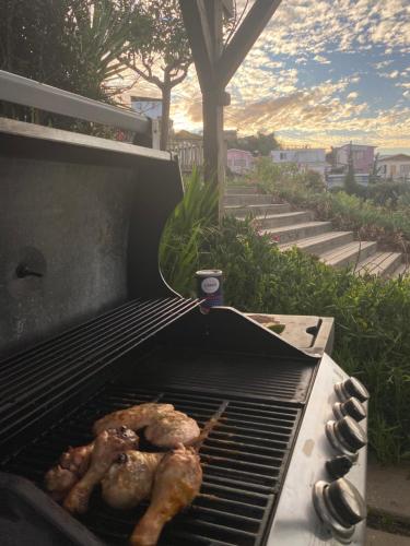 a grill with two chickens cooking on it at Hotel Faro Azul Valparaíso Cerro Alegre in Valparaíso