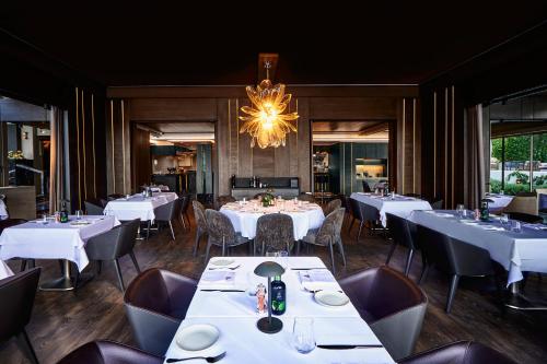 un ristorante con tavoli e sedie bianchi e un lampadario di Arbor İstanbul a Istanbul