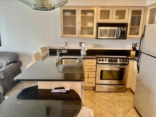 a kitchen with a sink and a stove top oven at Ocean Walk Resort Magnificent Ocean Front View in Daytona Beach