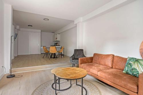 a living room with a couch and a table at Stijlvol & Comfortabel Appartement in het Hart van Rotterdam in Rotterdam
