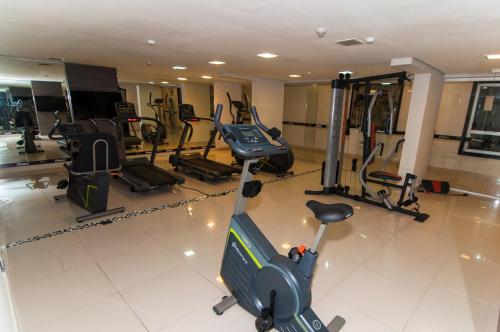 a gym with several treadmills and elliptical machines at Oscar Hotel Executive in Porto Velho