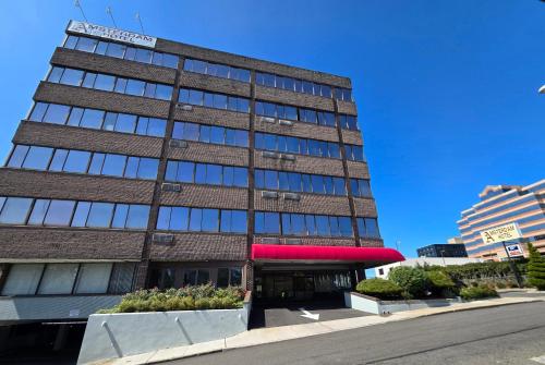a tall brick building with a red sign on it at Amsterdam Hotel in Stamford