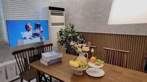 a dining room table with fruit on it with a tv at Busan Jeonpo Station 3min Rooftop Stay in Samgong