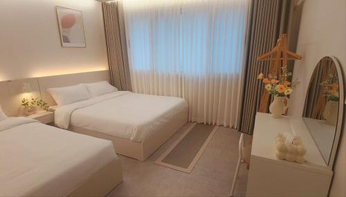 a hotel room with two beds and a window at Busan Jeonpo Station 3min Rooftop Stay in Samgong