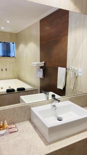a bathroom with a sink and a bath tub at POUSADA ESTÂNCIA in Penedo