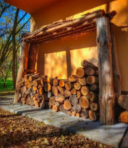 a pile of logs sitting next to a building at Varázslakos Tanya in Soltvadkert