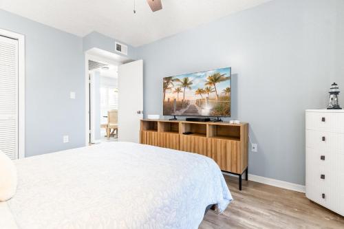 a bedroom with a white bed and a tv at The Villages of Seaport 144 in Cape Canaveral