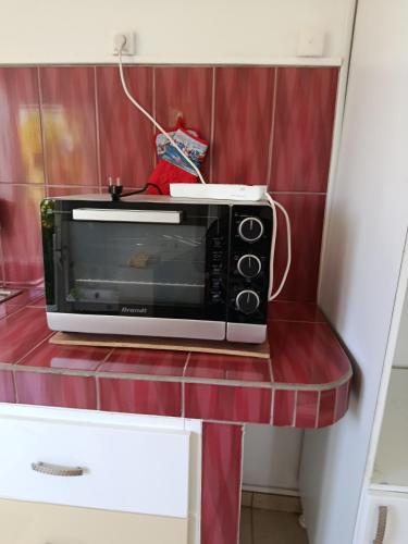 a microwave sitting on a counter in a kitchen at Orchidé in Sainte-Anne