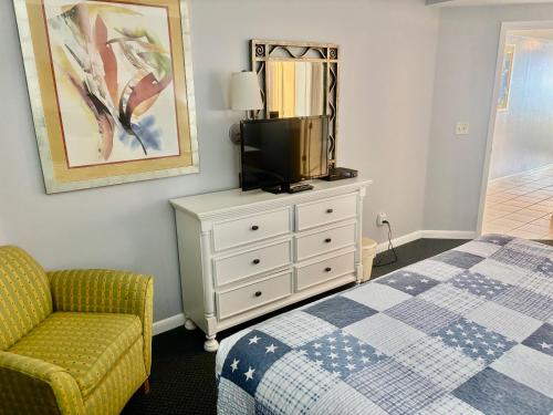 a bedroom with a bed and a tv and a chair at Ocean Walk Resort - Breathtaking Ocean Front View in Daytona Beach
