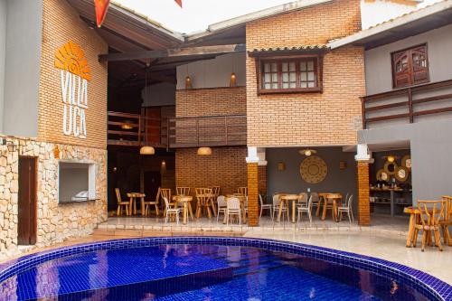 a patio with a pool and tables and chairs at Pousada Villa Uçá Frances - Praia do Frances in Marechal Deodoro