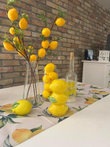 a table with a bunch of lemons and a vase with a bunch at Varázslakos Tanya in Soltvadkert