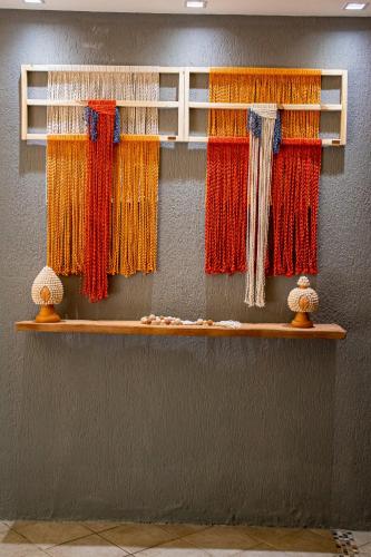 a wall with several different colored threads on shelves at Pousada Villa Uçá Frances - Praia do Frances in Marechal Deodoro