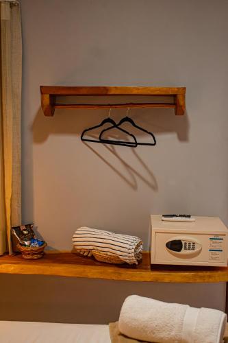 a shelf with a microwave and a radio on it at Pousada Villa Uçá Frances - Praia do Frances in Marechal Deodoro