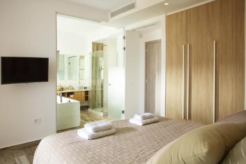 a bedroom with a bed with two towels on it at S&K Villas in Kalamaki Chanion
