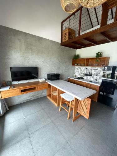 a kitchen with a table and a large screen tv at Suksma Guesthouse in Canggu