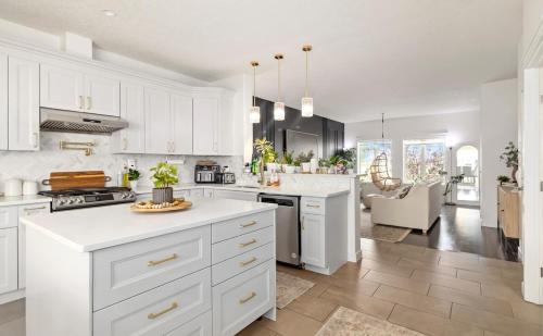 a kitchen with white cabinets and a white counter top at Entire Home - backyard oasis, indoor fireplace, Huge TV in Fort McMurray
