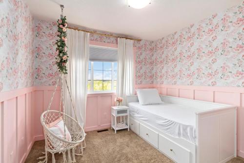 a pink room with a bed and a swing at Entire Home - backyard oasis, indoor fireplace, Huge TV in Fort McMurray