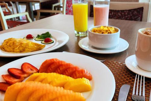 a table with two plates of food with fruit on it at Hotel Plaza Suites in Bogotá