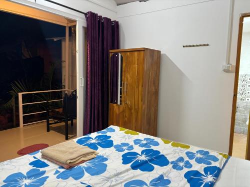 a bedroom with a bed with blue flowers on it at CSF Boutique Homestay in Palolem
