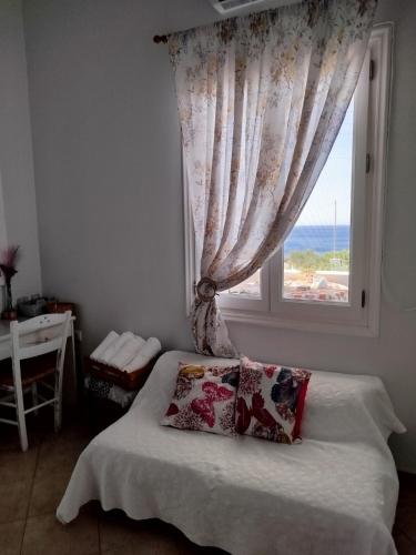 a bedroom with a window and a bed with a pillow at Captain George in Liaropá