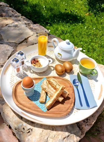 a table with a breakfast of eggs bread and coffee at L'eden Provençal in Les Saquetons