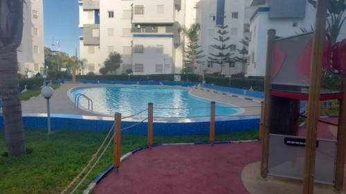 a swimming pool with a slide in a building at La vie de vacances fal azur in Bouznika