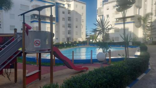 a girl on a slide by a swimming pool at La vie de vacances fal azur in Bouznika