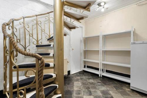 a spiral staircase in a room with shelves at 80182-Vemb-Ogelstrupvej-4 in Lillelund