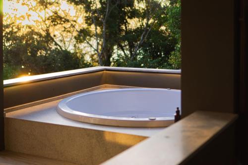 a bath tub sitting in front of a window at Naatooh Guest Houses in Florianópolis