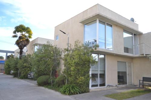 a house with a palm tree in front of it at De Triana Hotel in Rancagua