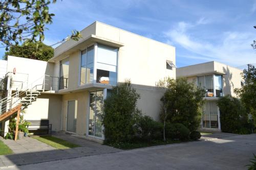 a white house with a lot of windows at De Triana Hotel in Rancagua