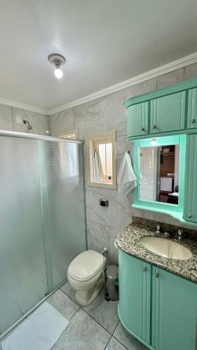 a bathroom with a toilet and a shower and a sink at Pousada Tedesco in Bento Gonçalves
