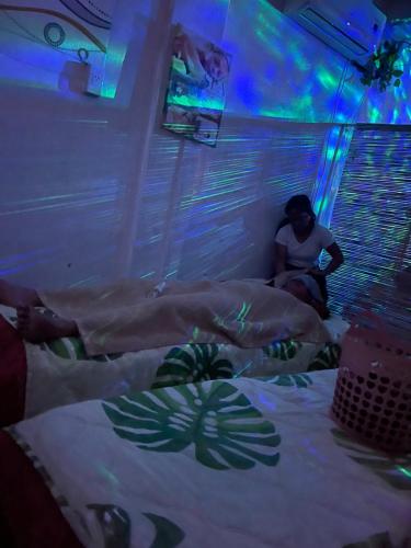a woman sitting on a bed in a room at Massaji&SPA-Massage Spa in Oslob