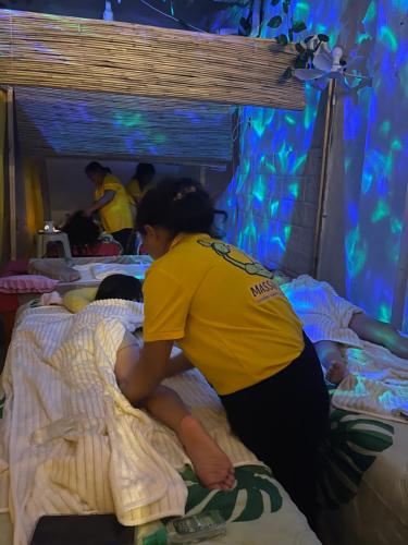 a woman is putting a baby on a bed at Massaji&SPA-Massage Spa in Oslob