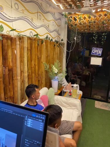 two people sitting on a couch with a laptop at Massaji&SPA-Massage Spa in Oslob