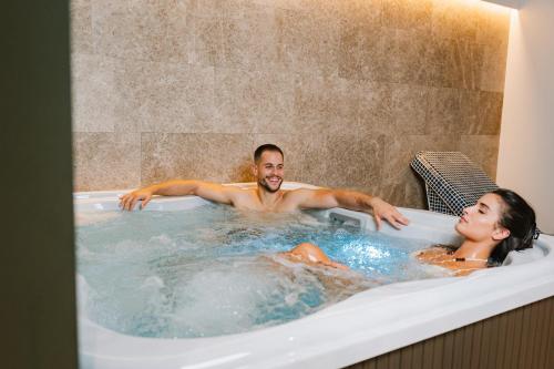 a man and a woman in a bath tub at Kondo Hotel Allure in Budva
