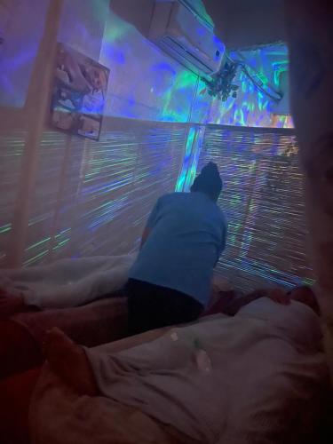 a man sitting on a bed looking out a window at Massaji&SPA-Massage Spa in Oslob