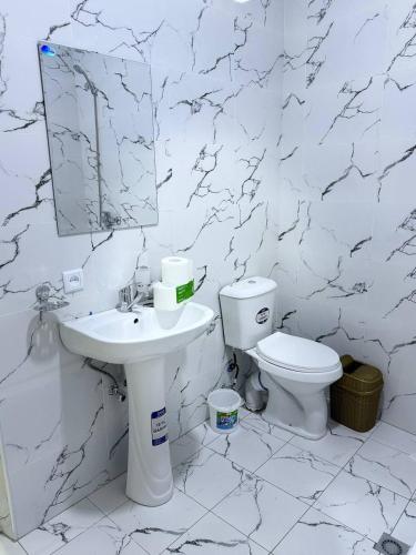 a white bathroom with a sink and a toilet at City Center Apartment "Afsona mall" in Irvadan