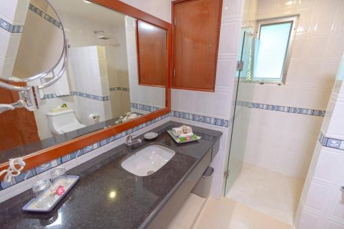 a bathroom with a sink and a mirror and a shower at Palmar del Sol by Riviera Maya Suites in Playa del Carmen