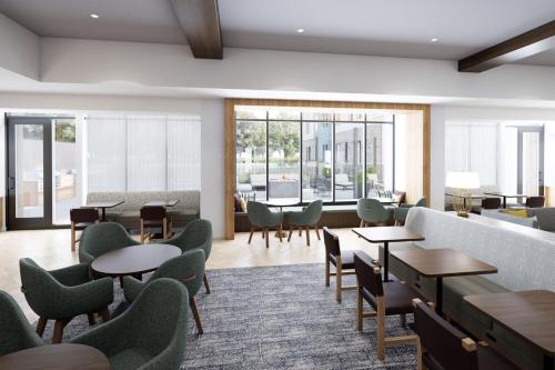a waiting room with tables and chairs and windows at Staybridge Suites Halifax - Dartmouth by IHG in Halifax