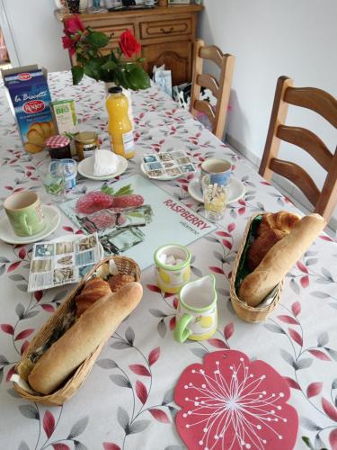 een tafel met een tafelkleed met broden bij Les hortensias in Soubran