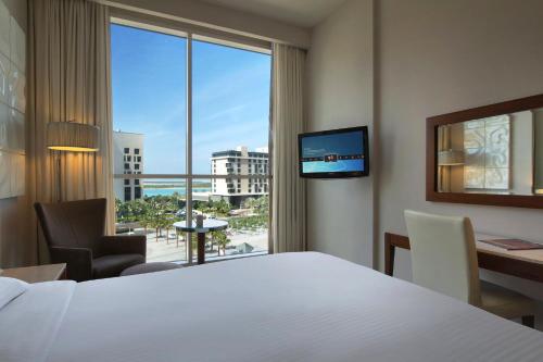 a hotel room with a bed and a large window at Yas Plaza Circuit by IHG in Abu Dhabi