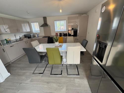 a kitchen with a table and chairs and a refrigerator at Detached 4BR House - Private Garden, Garage & Parking - Perfect for Long Stays, Families, Contractors in Canterbury