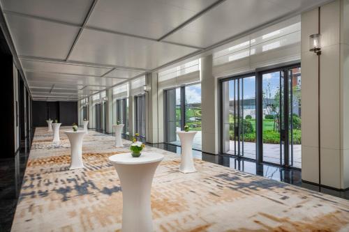 a row of white tables in a room with windows at Crowne Plaza Beijing Tongzhou in Beijing