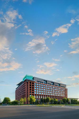 a large office building with a cloudy sky in the background at Crowne Plaza Beijing Tongzhou in Beijing