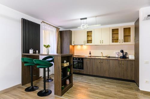 a kitchen with wooden cabinets and a green stool at OCCO by the Mountains in Braşov