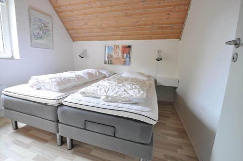 Habitación con 2 camas individuales y techo de madera. en 10613-Ulfborg-Svollingvej-37, en Øhuse