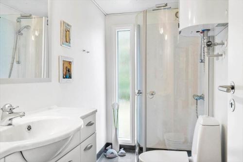 a white bathroom with a shower and a sink at 30138-Ulfborg-Bellisvej-513 in Vang